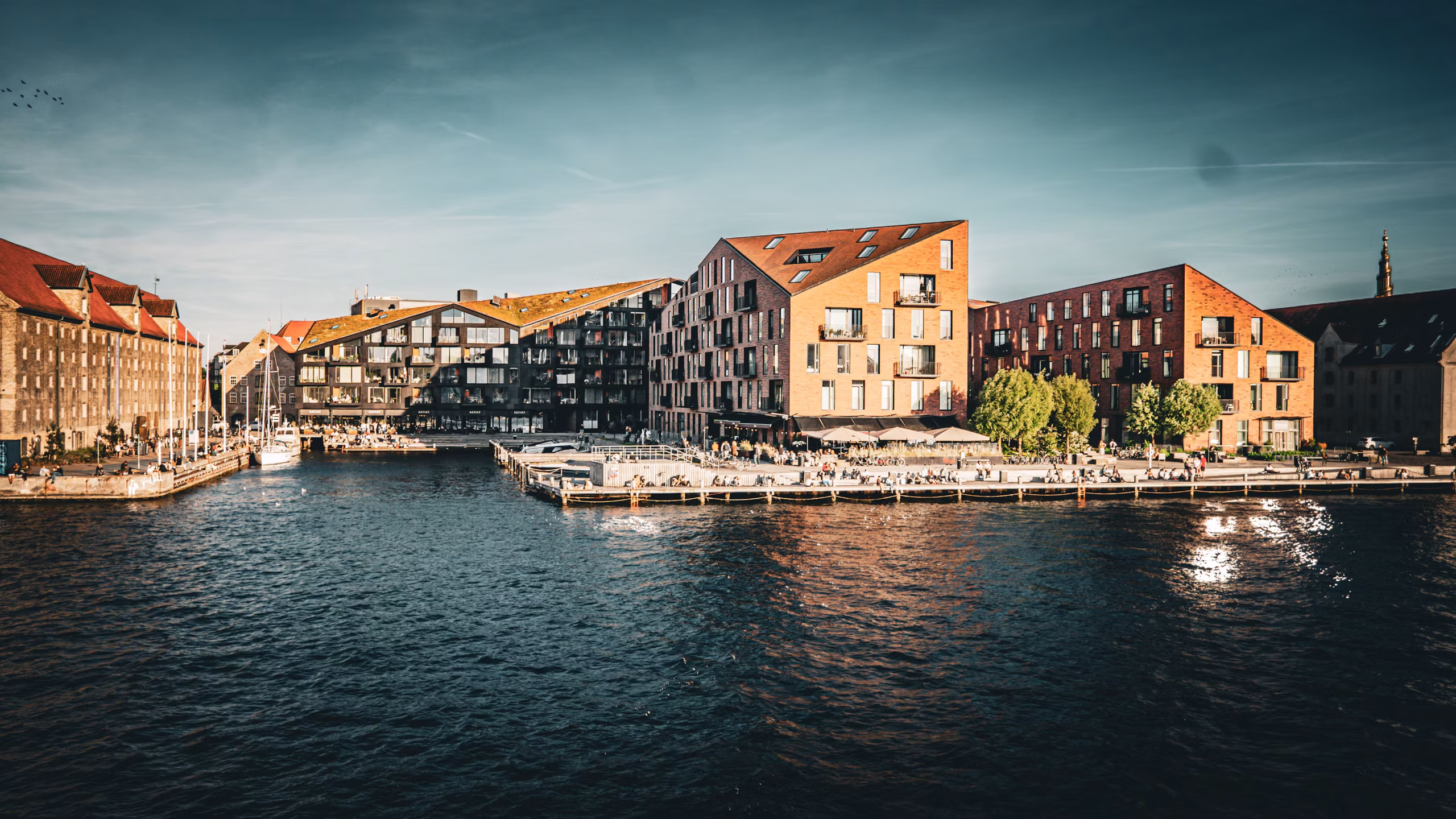 Edificios modernos bordean un canal soleado bajo un cielo despejado